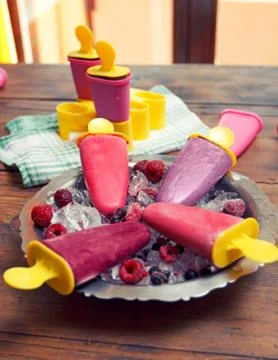 Popsicles on rustic wooden table 库存照片