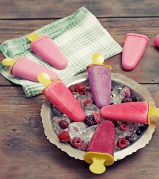 Popsicles on rustic wooden table 库存照片