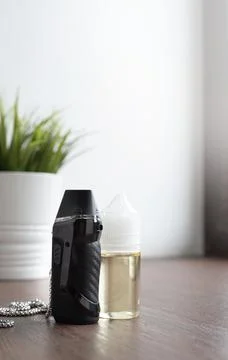 Popuar vaping device with liquid on windowsill Stock Photos