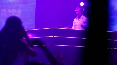 Popular Dutch DJ Armin Van Buuren on stage, many people at rave party Stock Footage 10680406