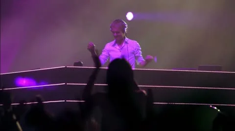 Popular Dutch DJ Armin Van Buuren on action, lot of people at rave party Stock Footage