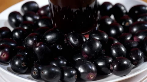 Popular Indian Java plum fruit kept on a white plate rotating on a turntable.... Stock Footage 157526880