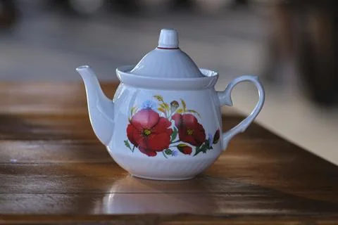 Porcelain teapot with a pattern stands on the table close-up Foto stock