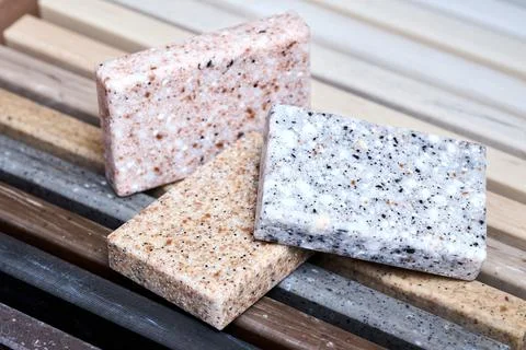Porcelain three stoneware square samples laid on kitchen countertop examples of Stock Photos