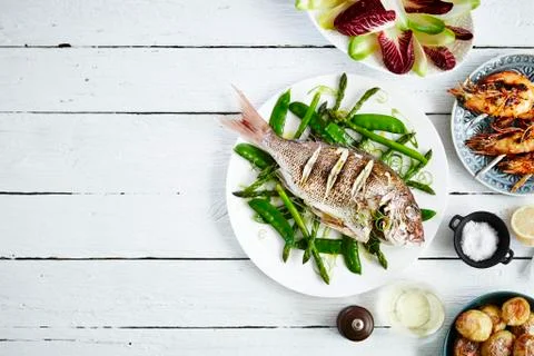 Porgy with mange tout and asparagus, prawns, salad and potatoes Stock Photos