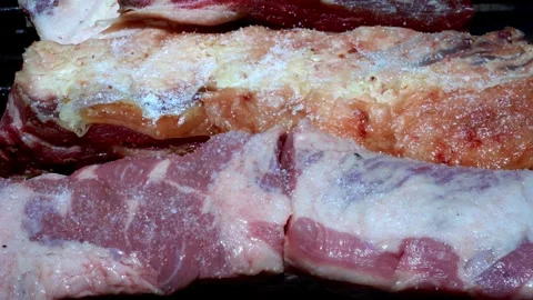Pork and beef put on the grill being salted Stock Footage 293366040