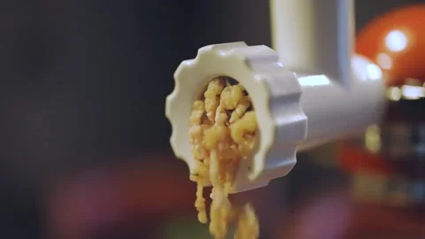 Pork and chicken being processed through an electric meat grinder Video stock 185513088