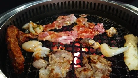 Pork and squid are grilled on the grill. Stock-Footage 87944005