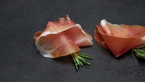 Pork bacon slice on back wooden cutting board. Slow motion Stock Footage 133605334