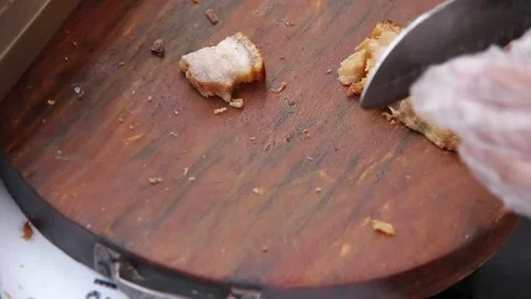 Pork is being cut into pieces using a knife on a cutting board Stock Footage 272298370