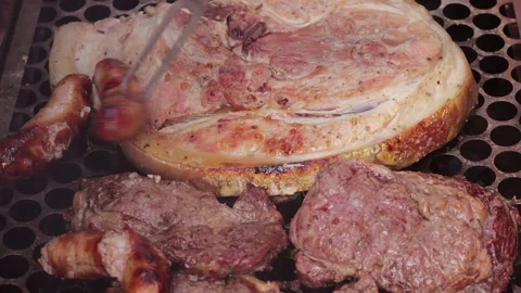Pork belly, beef steaks, and sausages grilling on the barbecue Vídeo Stock 337941111