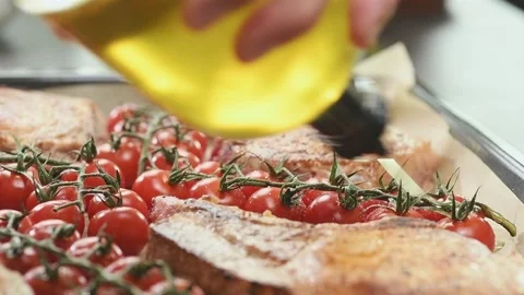 Pork chops with cherry tomatoes. Pouring olive oil over cherry tomatoes. Stock Footage 165621972