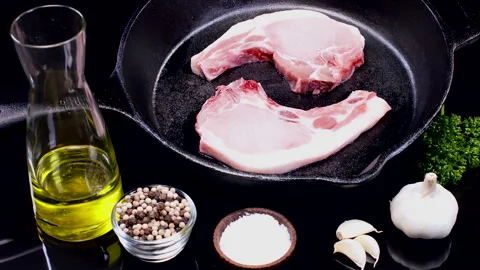 Pork Chops Skillet Rotation on a kitchen table Stock Footage 248744734