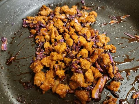 Pork chunks mixed with cabbage in frying pan or skillet Stock Photos