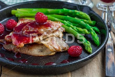 Pork cutlets with raspberry sauce and asparagus, horizontal Stock Photos