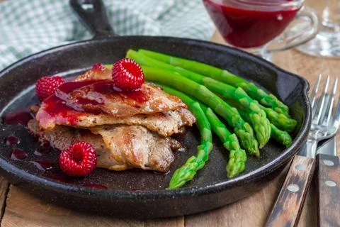 Pork cutlets with raspberry sauce and asparagus, horizontal 스톡 사진