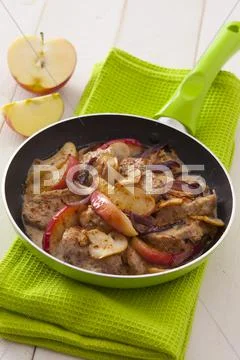 Pork fillet with apple wedges, red onions and mushrooms Stock Photos