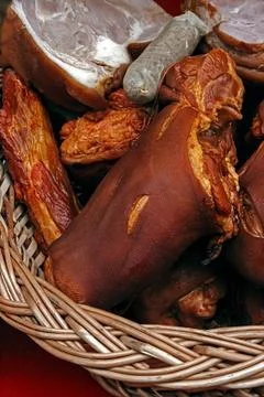 Pork ham and sausages placed in a wicker basket Stock Photos