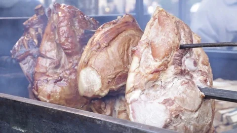 Pork meat cooking on a rotating spit Stock Footage 70193629