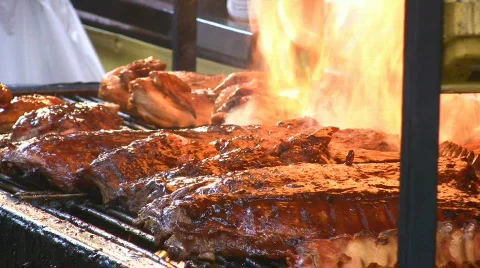 Pork Ribs On A Charcoal BBQ Flames Up Barbecue Ribfest Cook Off Stock Footage