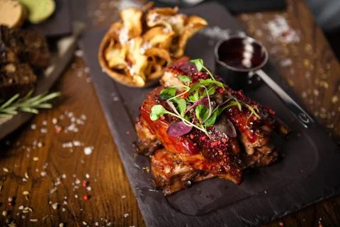 Pork ribs cooked at low temperature. Blackcurrant sauce, parsnip chips with Foto stock