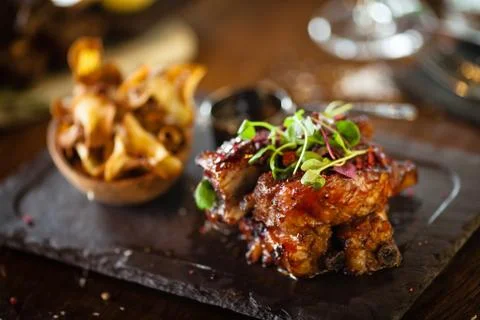 Pork ribs cooked at low temperature. Blackcurrant sauce, parsnip chips with Stock Photos
