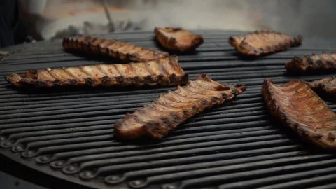 Pork ribs grill roasted on a rotating grill. Fried pork barbecue. Street food Stock Footage 124324480