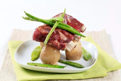 Pork ribs with potatoes, string beans and snow peas Stock Photos