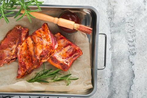 Pork ribs. Raw meat. Raw pork ribs in marinade with spices, rosemary, tomato  Stock Photos