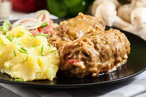 Pork rolls in sauce served with mashed potatoes and salad Stock Photos