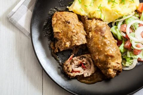 Pork rolls in sauce served with mashed potatoes and salad. Top view Stock Photos