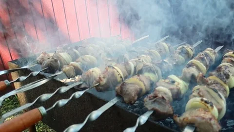 Pork shish kebab cooked on a brazier strung on a skewer, side view, smoke bil Vídeos de archivo 109547129