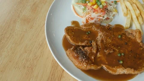 Pork steak with black pepper. Served with vegetables, salad, French fries Video stock 77263761