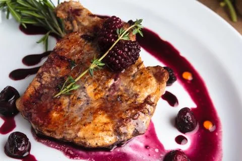 Pork steak on the bone with cherry-ginger sauce Stock Photos