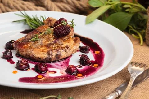 Pork steak on the bone with cherry-ginger sauce Stock Photos
