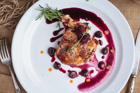 Pork steak on the bone with cherry-ginger sauce Stock Photos