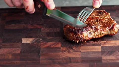 The pork steak is cut with a knife Видео 261068121