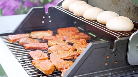 Pork Steaks and Bread Rolls Cooking on Garden Gas Grill Stock Footage 335698697