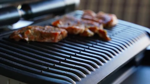Pork steaks being placed on an electric grill, close-up Stock Footage 315569492