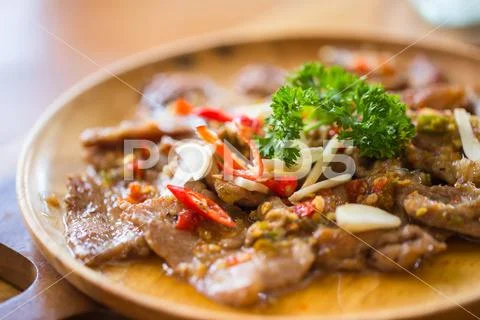 Pork Stir-Fly With Spicy Garlic Served On Wood Table, Thai Herbal Food Meal..