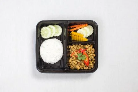 Pork with yellow curry paste and Rice put in black plastic box, put on a whit Stock Photos