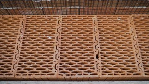 Porous ceramic blocks texture background. Worker puts a red ceramic block. Stock Photos