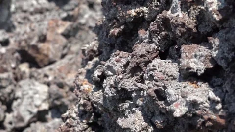 Porous surface texture of rough gray and maroon volcanic scoria rock fragment Stock Footage 327835740