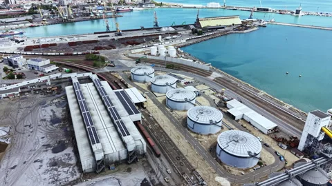 Port area with industrial tanks, loading equipment, and rail tracks near the Stock Footage 337917441