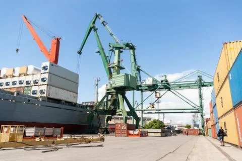 Port crane loading container ship with cargo Stock Photos
