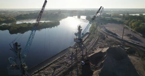 Port crane with a rotating boom working on loading river sand. 스톡 동영상 166317031
