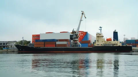 The port crane unloads containers with goods from the deck of a sea cargo ship Stock Footage 92204830