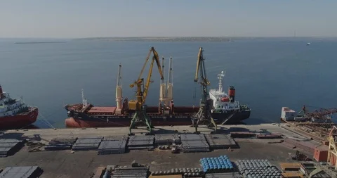 Port cranes load a dry cargo ship. The work of large port cranes 動画素材 118907722