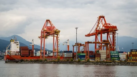 Port cranes loading and unloading cargo from a container ship - 4K Stock Footage 107438817