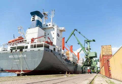Port cranes loading container ship with cargo Stock Photos